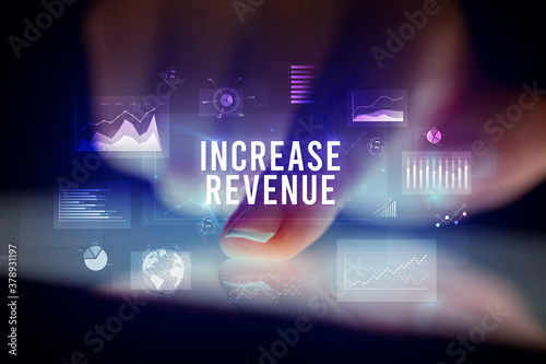 Finger touching tablet with charts and INCREASE REVENUE inscription, business concept
