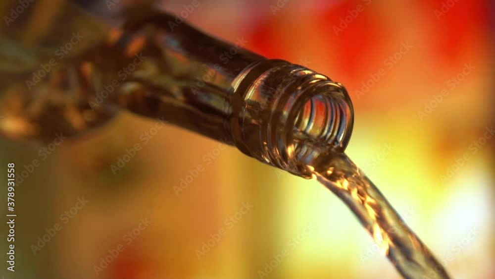 White wine pouring on colorful blurred background slow motion video. Christmas or new year celebration White wine pouring on colorful blurred background slow motion video. Christmas or new year celebration