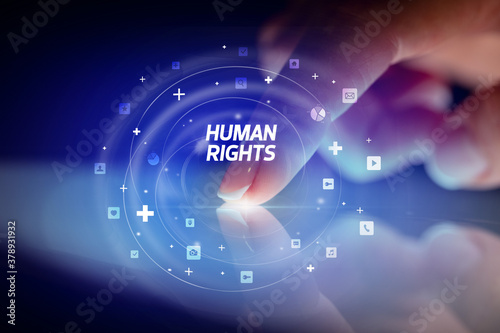 Finger touching tablet with social media icons and HUMAN RIGHTS