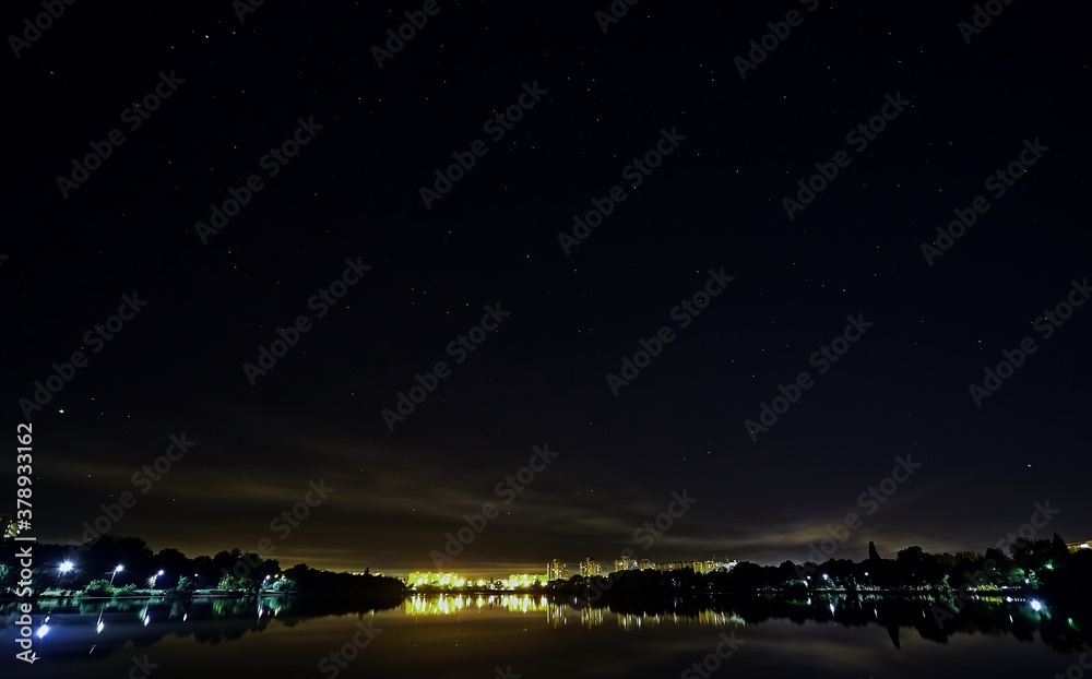 Lake in the night city under the starry sky.