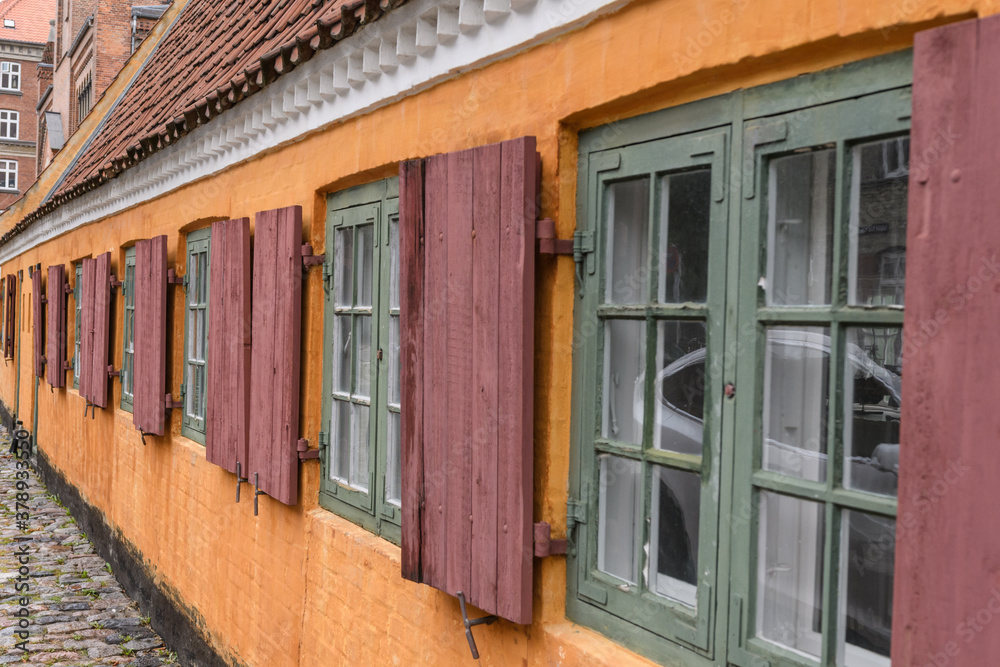 Historische Fassade orange mit Fenstern, Ausschnit 