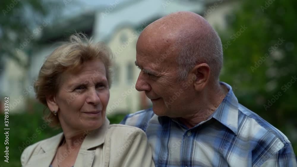 elderly married couple, old man and woman are embracing outdoors, sitting in park at summer day elderly married couple, old man and woman are embracing outdoors, sitting in park at summer day