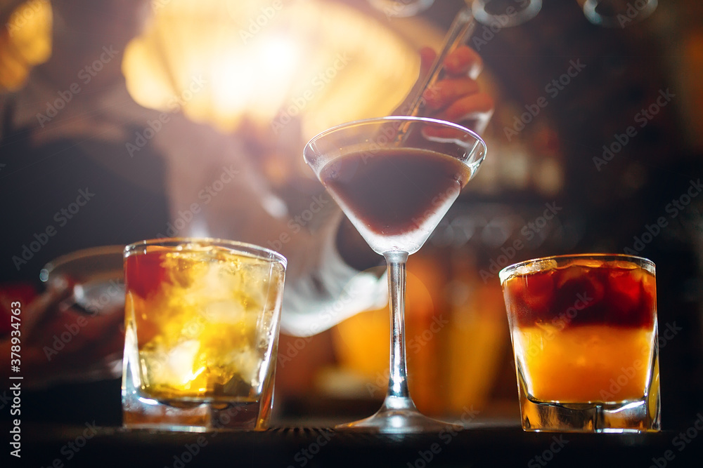 The bartender prepares cocktails at the bar. The bartender prepares cocktails at the bar.