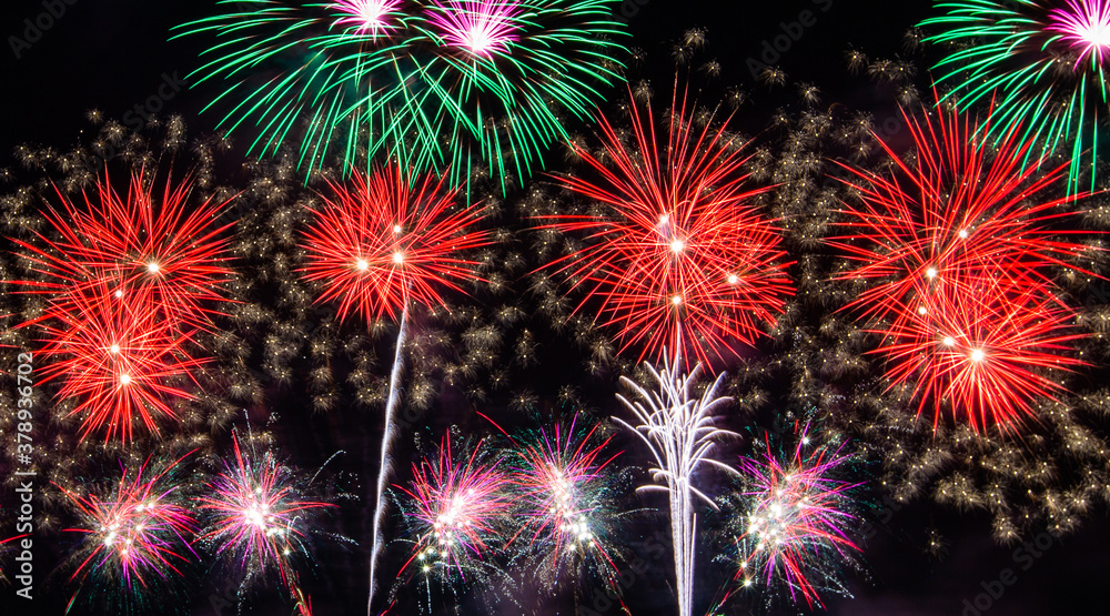 Colorful fireworks explosion and display on night sky.