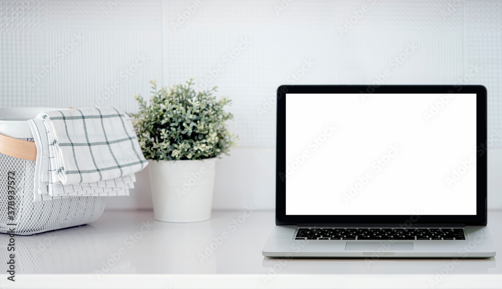 Mockup laptop computer with blank screen on white top table in kitchen room, copy space. Mockup laptop computer with blank screen on white top table in kitchen room, copy space.