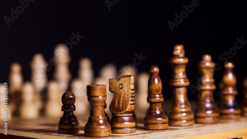 Wooden chess in a contrasting light. A game of chess  an intellectual competition 