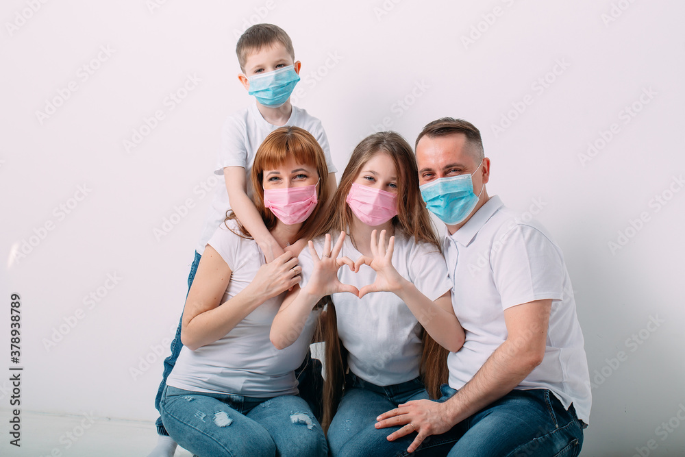 young family in medical masks during home quarantine.