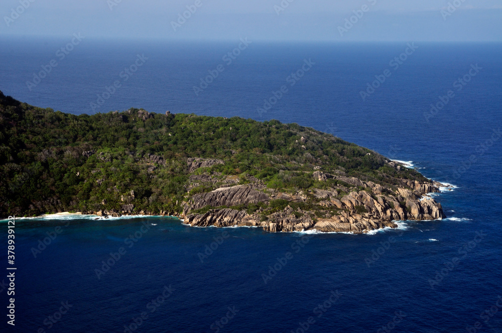 Aerial view of a tropical island with coastline and blue ocean. Félicité Island, La Digue, Seychelles
