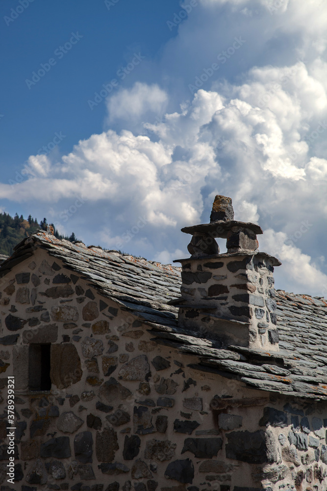 Cheminée traditionnelle sur un toit de lauzes