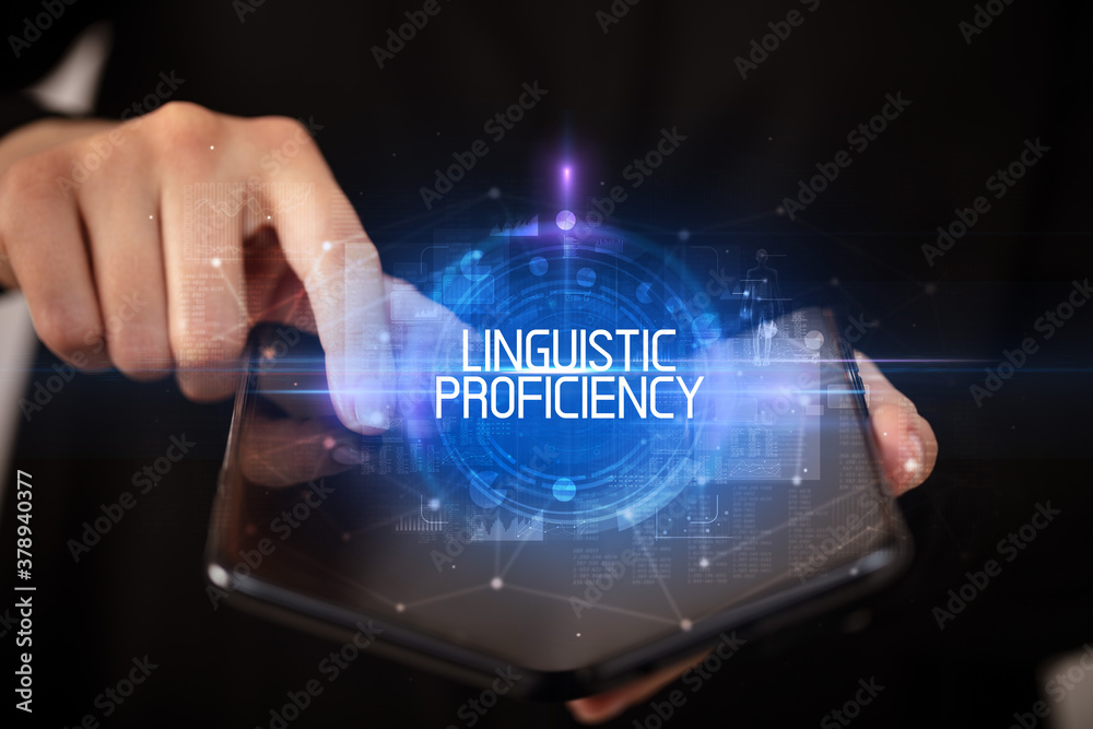 Young man holding a foldable smartphone with LINGUISTIC PROFICIENCY inscription, educational concept Young man holding a foldable smartphone with LINGUISTIC PROFICIENCY inscription, educational concept