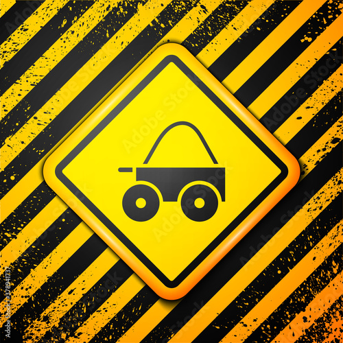 Black Wooden four-wheel cart with hay icon isolated on yellow background. Warning sign. Vector.