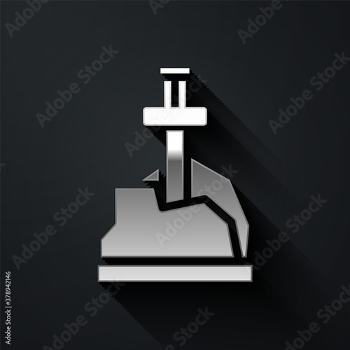 Silver Sword in the stone icon isolated on black background. Excalibur the sword in the stone from the Arthurian legends. Long shadow style. Vector.