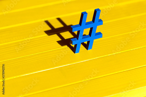 Blue hashtag on the wood yellow background