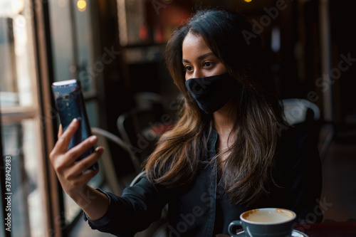 Young woman with face mask in cafe