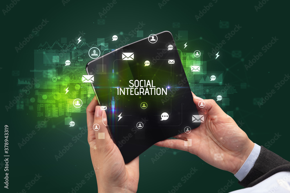 Businessman holding a foldable smartphone with SOCIAL INTEGRATION inscription, social networking concept Businessman holding a foldable smartphone with SOCIAL INTEGRATION inscription, social networking concept
