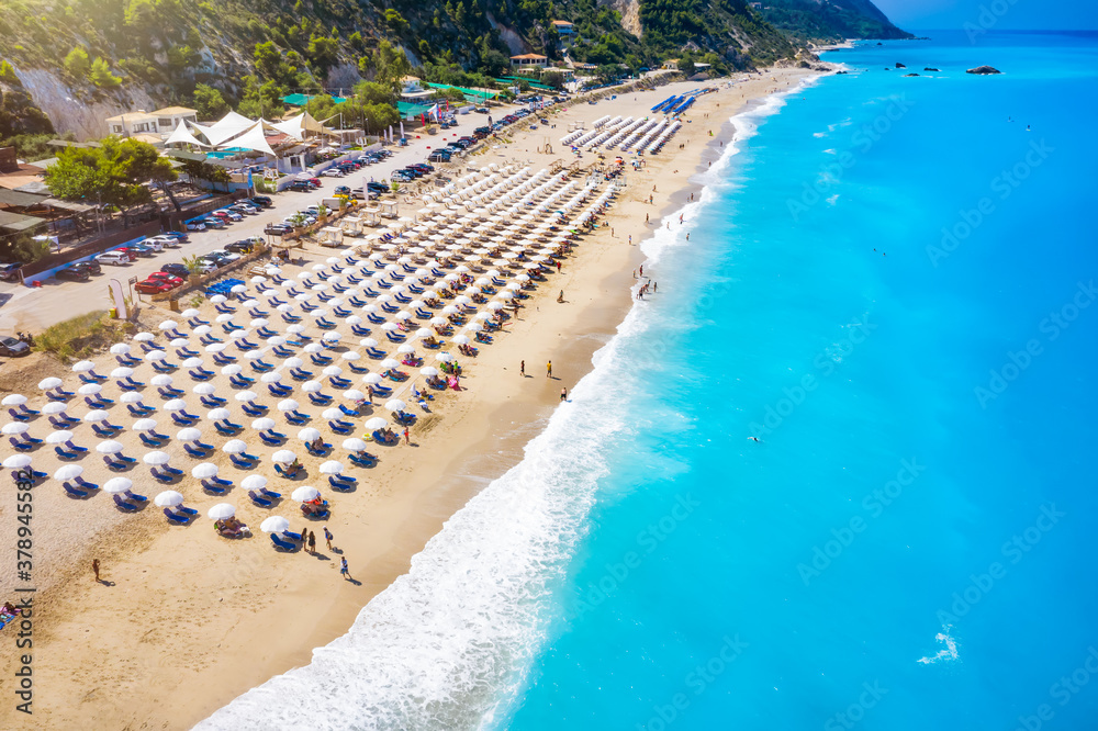 The popular Kathisma Beach on the Greek island of Lefkada with blue sea and rows of umbrellas, Greece
