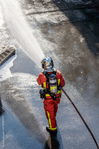 French firefighter with fire hose shot from above