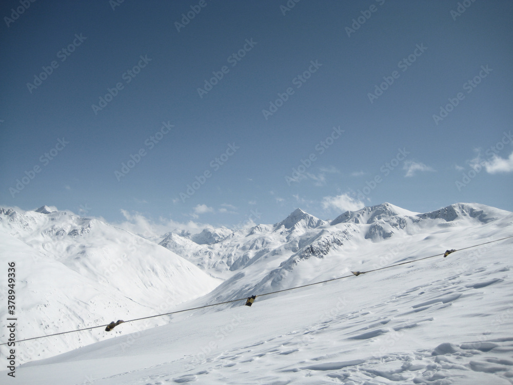 snow white winter piste in the northern alps under blue sky
