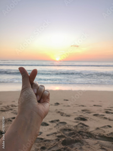 mini heart sign for love and care isolated with sunset on the beach background