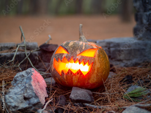 Calabaza de halloween con fuego en su interior en un bosque para celebrar el día de muertos o de todos los santos