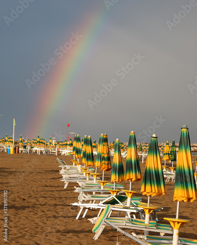 Rainbow After the storm on the sky and the deckchairs  and umbre photo