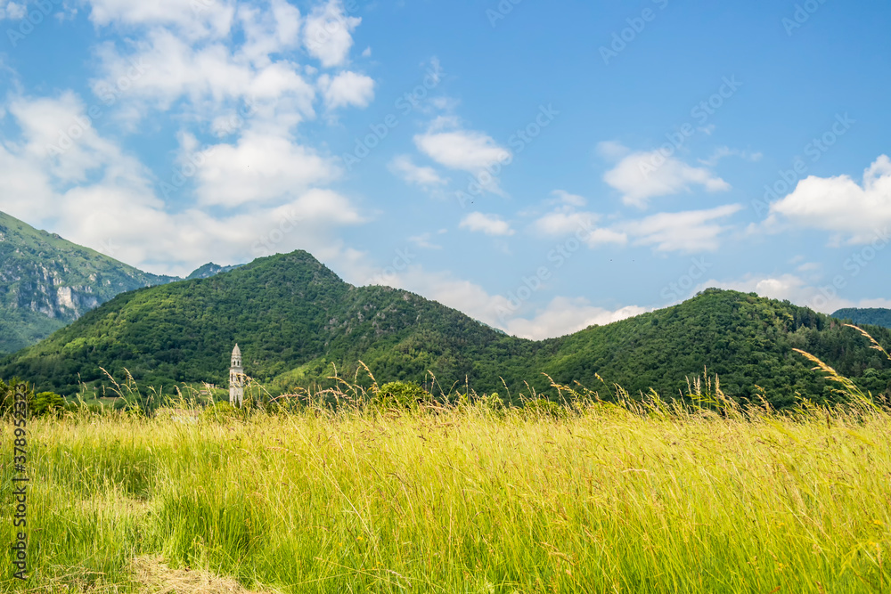 Rural background with bell tower and mountains