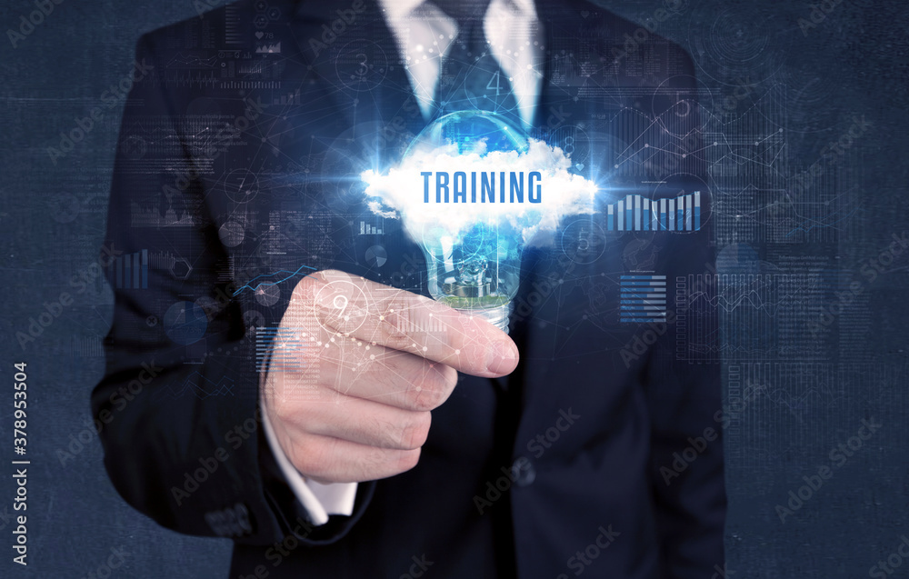 Businessman holding a light bulb with TRAINING inscription, new business concept Businessman holding a light bulb with TRAINING inscription, new business concept