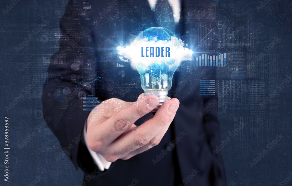 Businessman holding a light bulb with LEADER inscription, new business concept Businessman holding a light bulb with LEADER inscription, new business concept