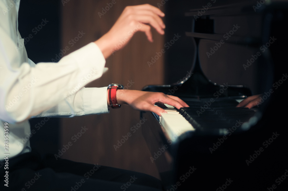 Musicians play the piano using his hands. Selective focus