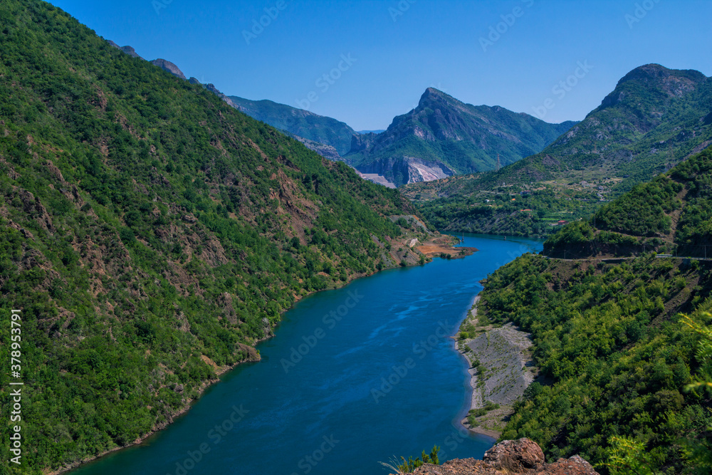 Beautiful summer landscape with blue river in Albanian mountains, covered with lush foliage