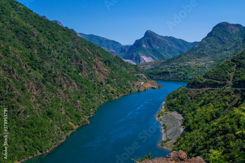 Beautiful summer landscape with blue river in Albanian mountains  covered with lush foliage