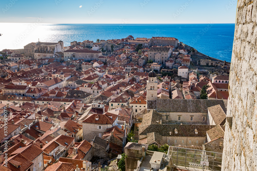 Colorful fortress street walk scene, clear sky sunny day. Beautiful high angle scene. Winter view of Mediterranean old city of Dubrovnik, famous European travel and historic destination, Croatia