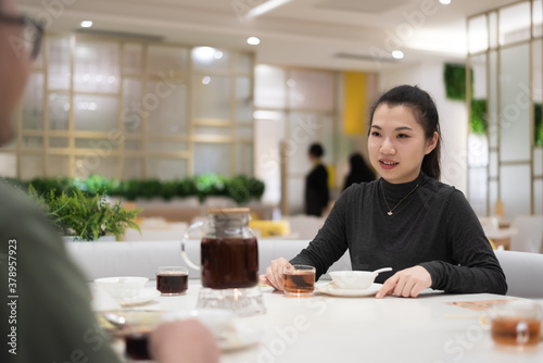 Young women talking face to face with others in the restaurant