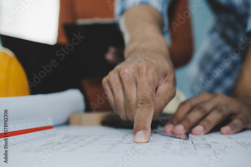 group of colleagues architect or interior designer planning and working on blueprint on desk in meeting room office at construction site, contractor, construction industrial, engineering concept