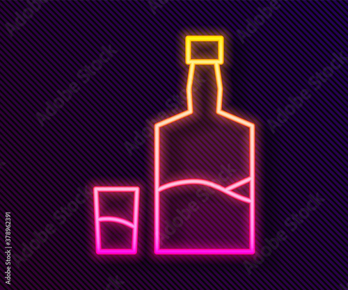 Glowing neon line Tequila bottle and shot glass icon isolated on black background. Mexican alcohol drink. Vector.