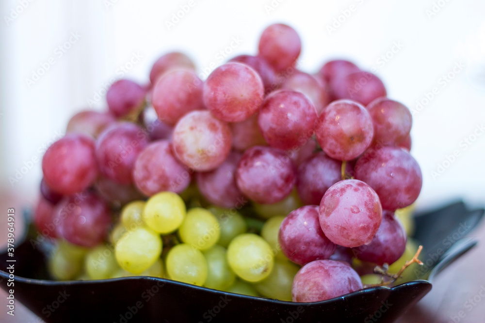 Red and White wine bunch of grapes in the black plate Red and White wine bunch of grapes in the black plate