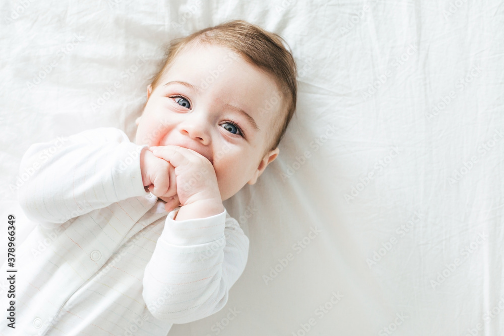 Newborn toddler boy laughing on the bed and looking at the camera Newborn toddler boy laughing on the bed and looking at the camera