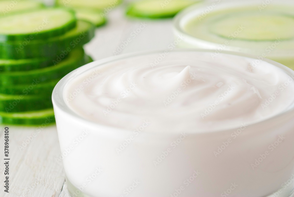 Moisturizer with cucumber slices on white wooden Moisturizer with cucumber slices on white wooden