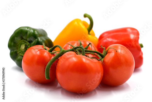 Red tomatoes and peppers on the light background.