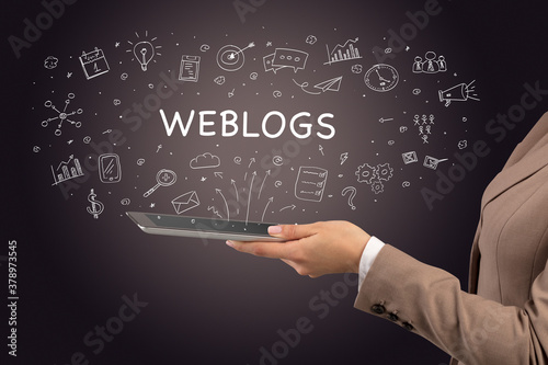Close-up of a touchscreen with WEBLOGS inscription, social media concept