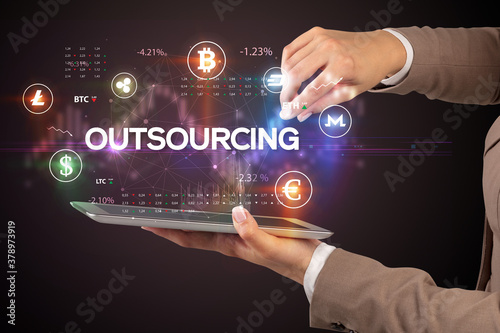 Close-up of a touchscreen with OUTSOURCING inscription, business opportunity concept