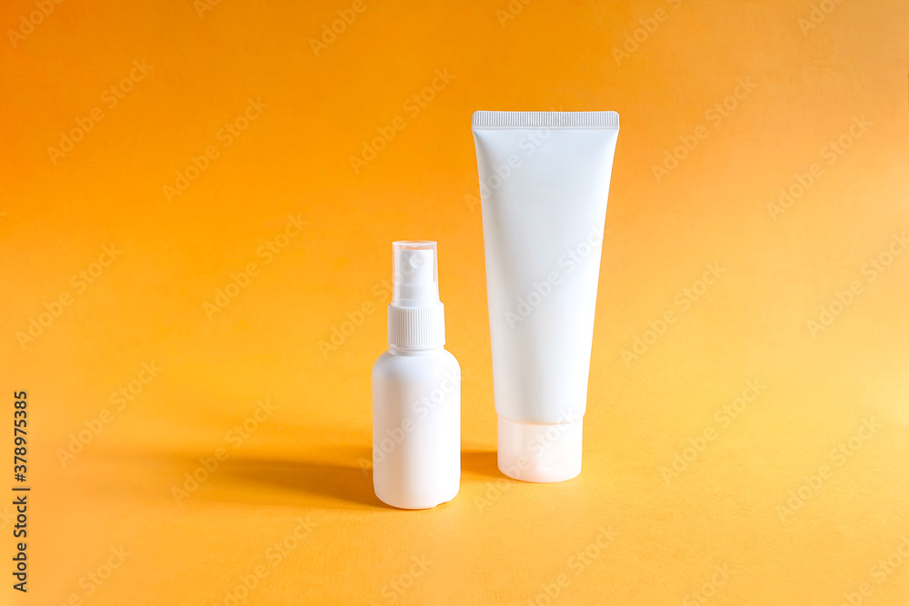 Mockups of two unbranded white bottle for branding and label on a textured bright orange background. One of them is squeeze bottle plastic tube. Other is plastic spray bottle. Natural organic spa Mockups of two unbranded white bottle for branding and label on a textured bright orange background. One of them is squeeze bottle plastic tube. Other is plastic spray bottle. Natural organic spa