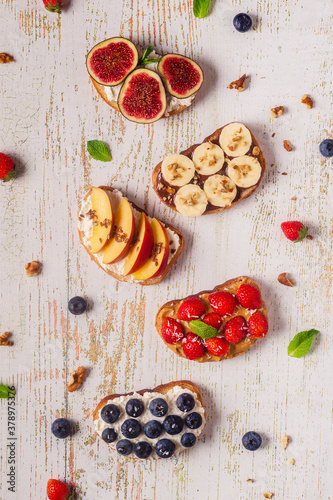 Homemade summer toast with cream cheese, nut butter and fruits and berries