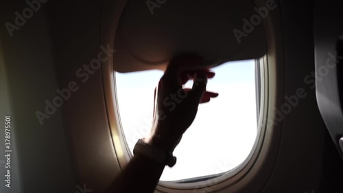 Wallpaper Mural Closeup view of sunny window of flying airplane. Man closes porthole. Torontodigital.ca