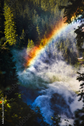 Regenbogen im Wald mit Wasserdampf von einem Wasserfall