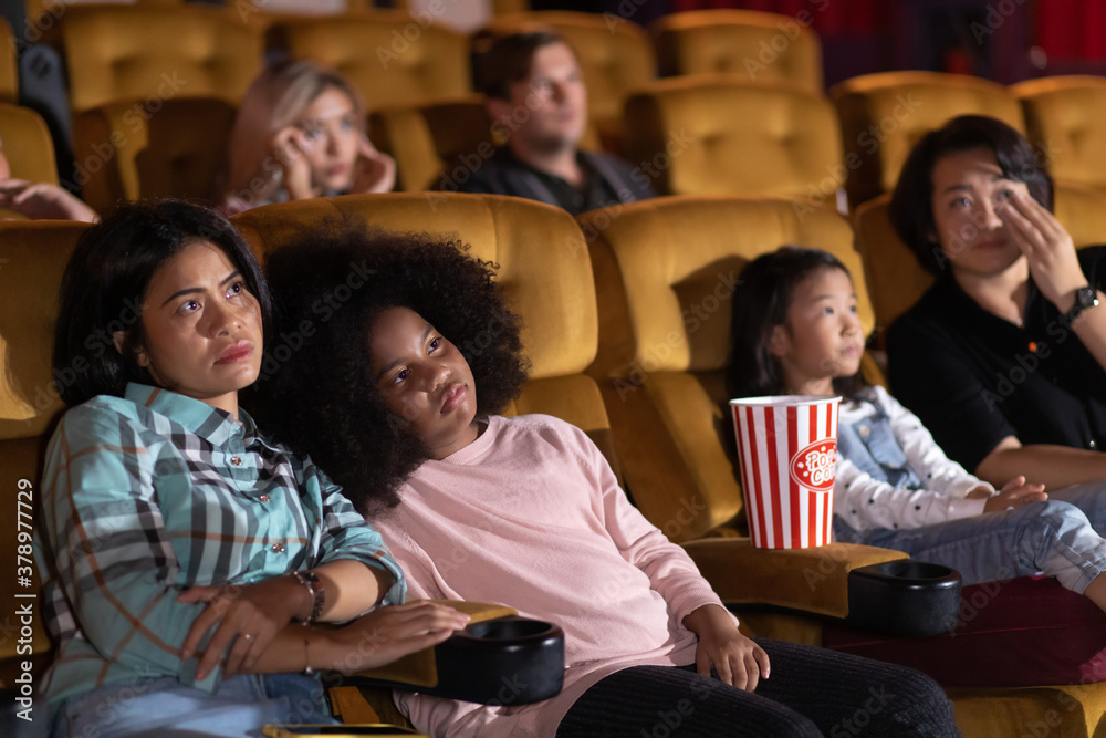 Happy family watching movie in cinema theatre. Happy family time in holiday Happy family watching movie in cinema theatre. Happy family time in holiday
