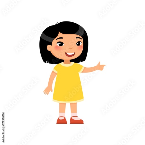 Little asian girl pointing with index finger flat vector illustration. Smiling female child in dress standing cartoon character. Kid showing direction, paying attention gesture