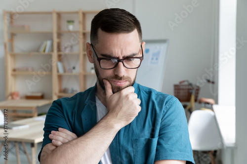 Bild auf Leinwand Thoughtful young businessman wearing glasses thinking about problem solution clo