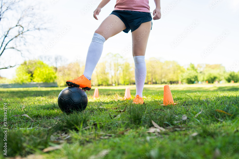 Young female soccer player practicing on field. Young female soccer player practicing on field.