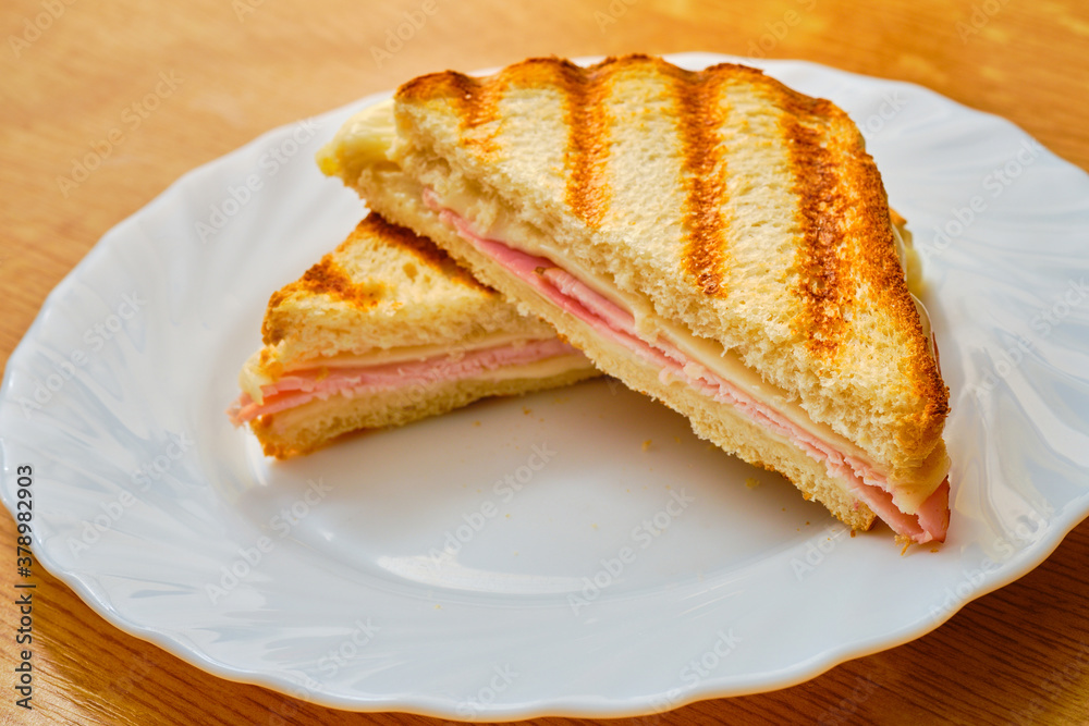 Ham and cheese toast on white plate Ham and cheese toast on white plate